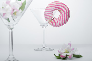  A flower in a glass close-up for a screensaver. In the background is a donut glass. And next to it is a pink flower.
