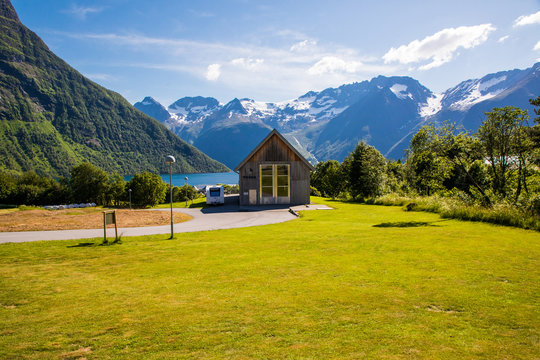 Picturesque scene of Urke village and Hjorundfjorden fjord, Norway. Drammatic sky and gloomy mountains. Landscape.