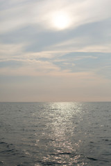 Natural background. The sun goes down to the horizon above the sea or ocean. Sunset over the water.