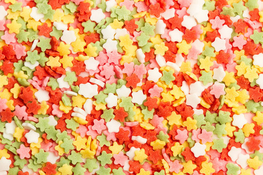 Granas y grageas de colores en forma de estrellas. Vista superior macro. 