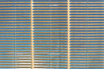 Vertical aerial view of a photovoltaic solar panel farm producing sustainable renewable energy in a desert power plant.