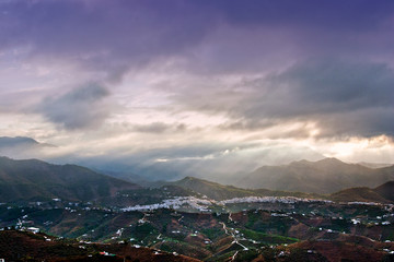 Storm clouds surrounding The Moorish village of Frigiliana nestling in the mountains, Costa del Sol, Andalucia, Spain