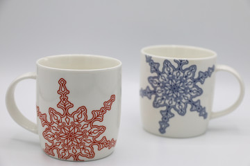Blue and red Christmas mugs on a white background