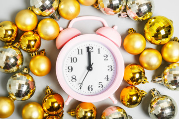  pink alarm clock and golden christmas balls. midnight on New Year's or Christmas night. New Year...