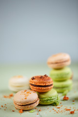 Colorful background with delicious french green and orange macaroons
