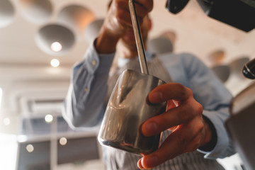 Barman using professional coffee machine in cafe