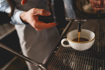 Fototapeta na wymiar Male barista using professional coffee machine in cafe