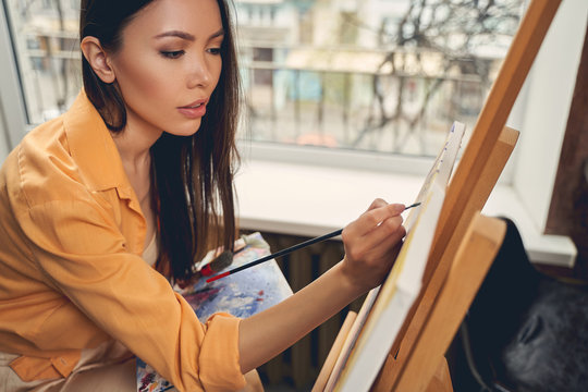 Attractive Young Woman Painting Picture At Home