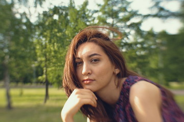 Naklejka premium Portrait of a girl in a park. The face of a beautiful girl close-up.