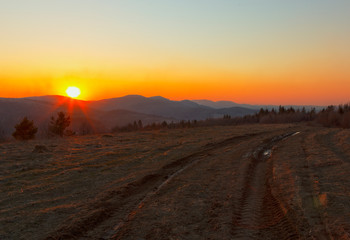 landscape of the Carpathians in spring. the last rays of the sun above the horizon illuminate the glade and the forest. Wonderful landscape of the spring Carpathians, the moment of sunset.