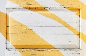 Yellow stripes on white wooden background.