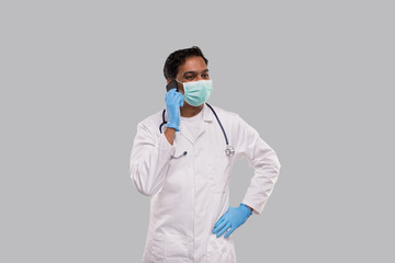Doctor Talking on Phone Wearing Medical Mask and Gloves. Indian Man Doctor with Phone Isolated