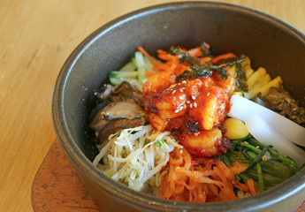 Closeup Bibimbap or Korean Traditional Mixed Rice with Meat and Assorted Vegetables in Hot Stone Bowl