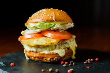 hamburger with chicken, pineapple and vegetables on a plate