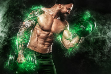 Athlete in green energy lights. Muscular young fitness sports man bodybuilder doing workout with...