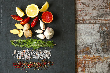 Set of seasonings and spices on a black stone board. Food background. Healthy food concept. Spices for pickling meat or fish.