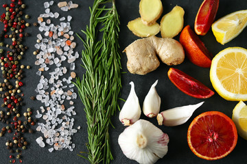 Set of seasonings and spices on a black stone board. Food background. Healthy food concept. Spices for pickling meat or fish.