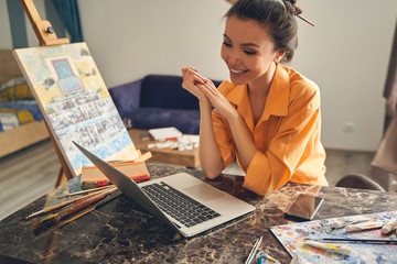 Cute smiling lady talking with friend through video call