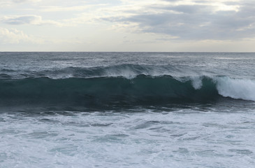 Close up of sea level while creating the perfect wave for surfers. The wave begins to flip and fall to the rest of the sea level. Stormy sea after a strong wind. Paphos, Cyprus