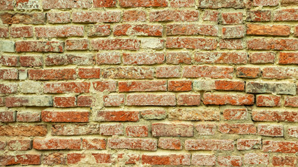 crumbling Church wall of red brick with plaster