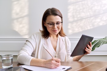 Woman teacher, mentor, psychologist looking at webcam of digital tablet