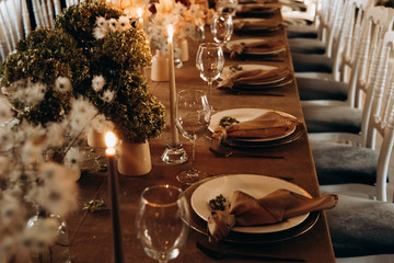 wedding table setting for a dinner with flowers and candles