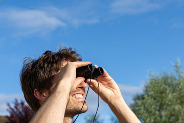 Jeune homme regardant à travers des jumelles