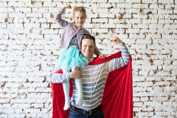 Obraz na płótnie Canvas happy father in superhero costume and his daughter