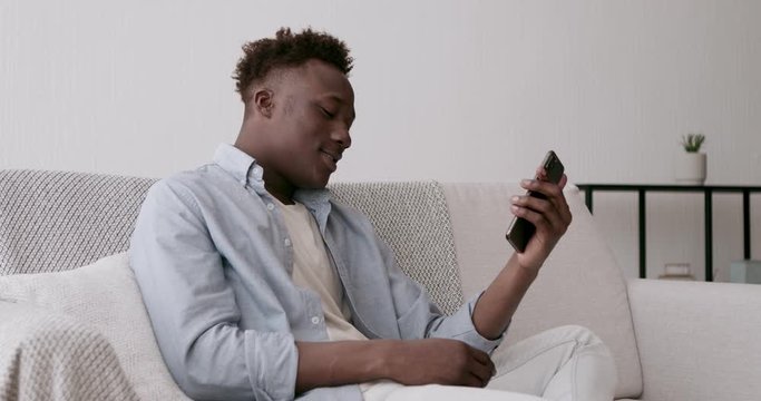 Young black man video calling to family with mobile phone
