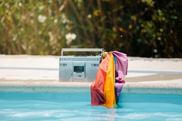 Naklejka premium Metal radio cassette with an lgtb flag attached to the handle on a pool