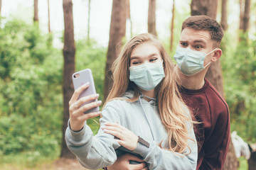 Fototapeta premium Medical masked couple taking selfie,Couple taking selfie in the forest