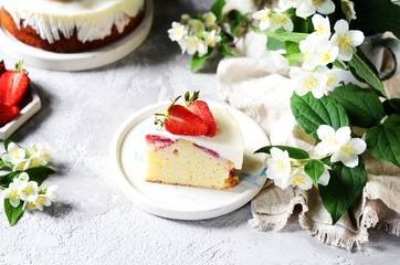 Obraz na płótnie Canvas Strawberry cake with cream in a plate on a gray background