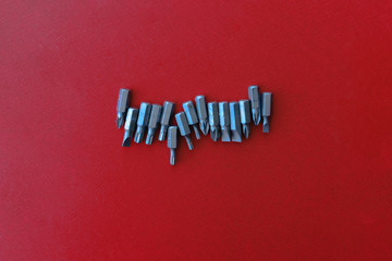 Screwdrivers, bits, construction metal, for repairs on a uniform red background, workspace