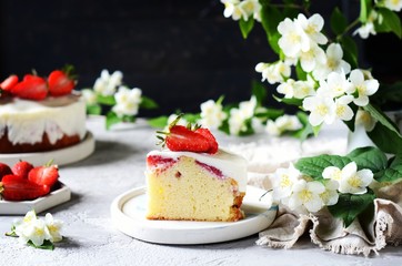 Obraz na płótnie Canvas Strawberry cake with cream in a plate on a gray background