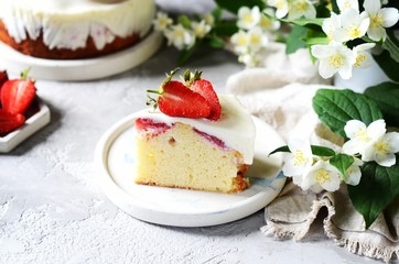 Strawberry cake with cream in a plate on a gray background
