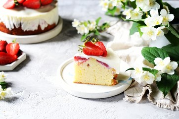 Strawberry cake with cream in a plate on a gray background
