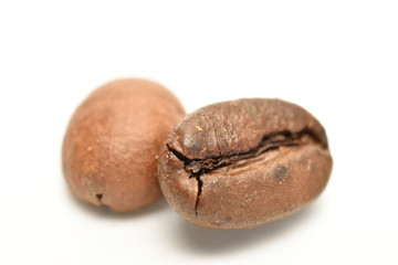 Fragrant roasted coffee grains, close-up, on a white background
