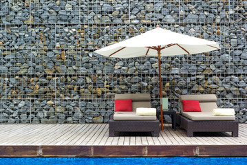 Beach chairs near swimming pool in tropical resort