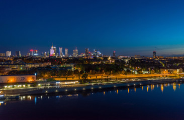 Fototapeta na wymiar night aerial panorama of Warsaw center across Wisla river with reflection