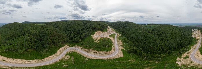 Full 360 equirectangular spherical panorama of aerial top vew of winding road in the mountains,...