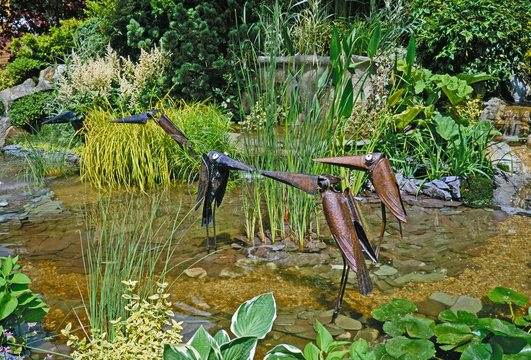 A decorative novelty planted Water Garden with metal birds and water plants