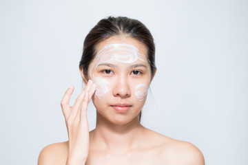 Young beautiful woman applying yogurt facial mask Skin care, beauty treatments on white background