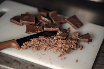 Knife and dark chocolate on a cutting board, cooking food with chocolate