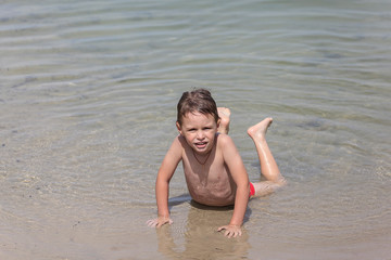 Happy little boy is swimming in the lake