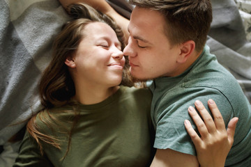 Close-up portrait of affectionate kissing couple in casual clothes, top view