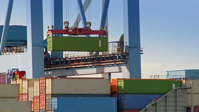 A Gantry crane is loading a container on a ship at daytime in the port of Hamburg / Germany