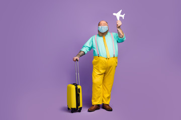 Full length body size view of his he funky guy hipster big abdomen hold card plane travel weekend wear mask suspenders pants open borders abroad destination isolated purple color background