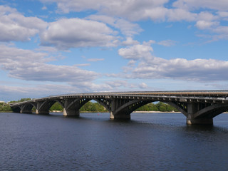 Fototapeta na wymiar View of the Dnieper river and metro bridge in a cloudy day, Kyiv, Ukraine.