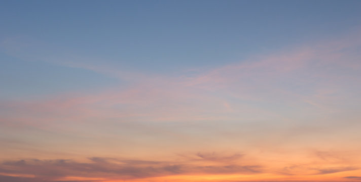 Beautiful sky painted by the sun leaving bright golden shades.Dense clouds in twilight sky in winter evening.Image of cloud sky on evening time.Evening sky scene with golden light from the setting sun