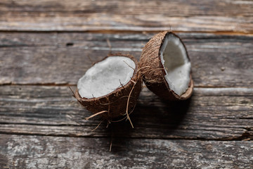 Ripe half cut coconut on a wooden background. Ripe half cut coconut on a wooden background. Coconut cream and oil.